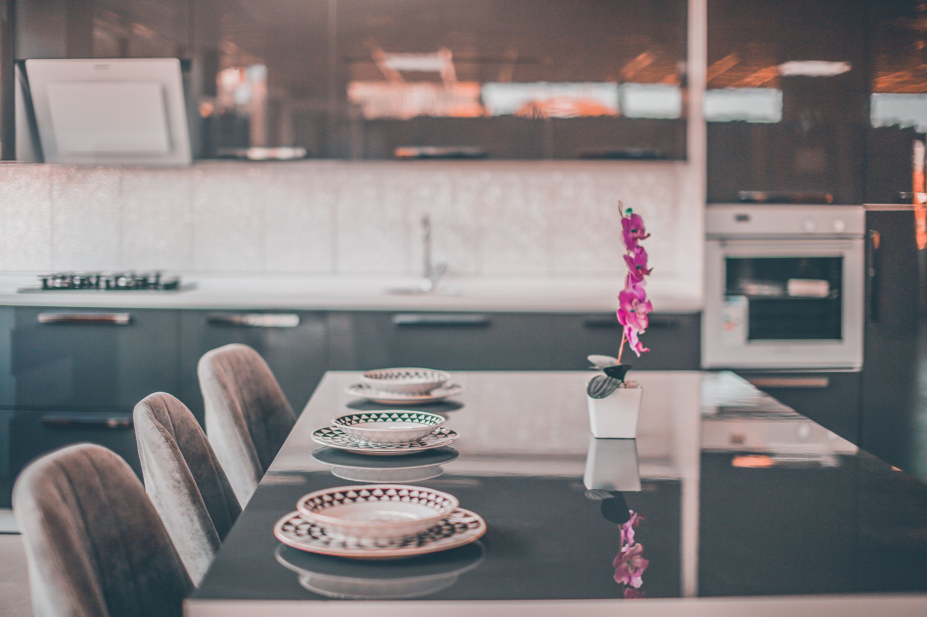 Stylish kitchen with sleek countertops, elegant decor, and a vibrant orchid centerpiece